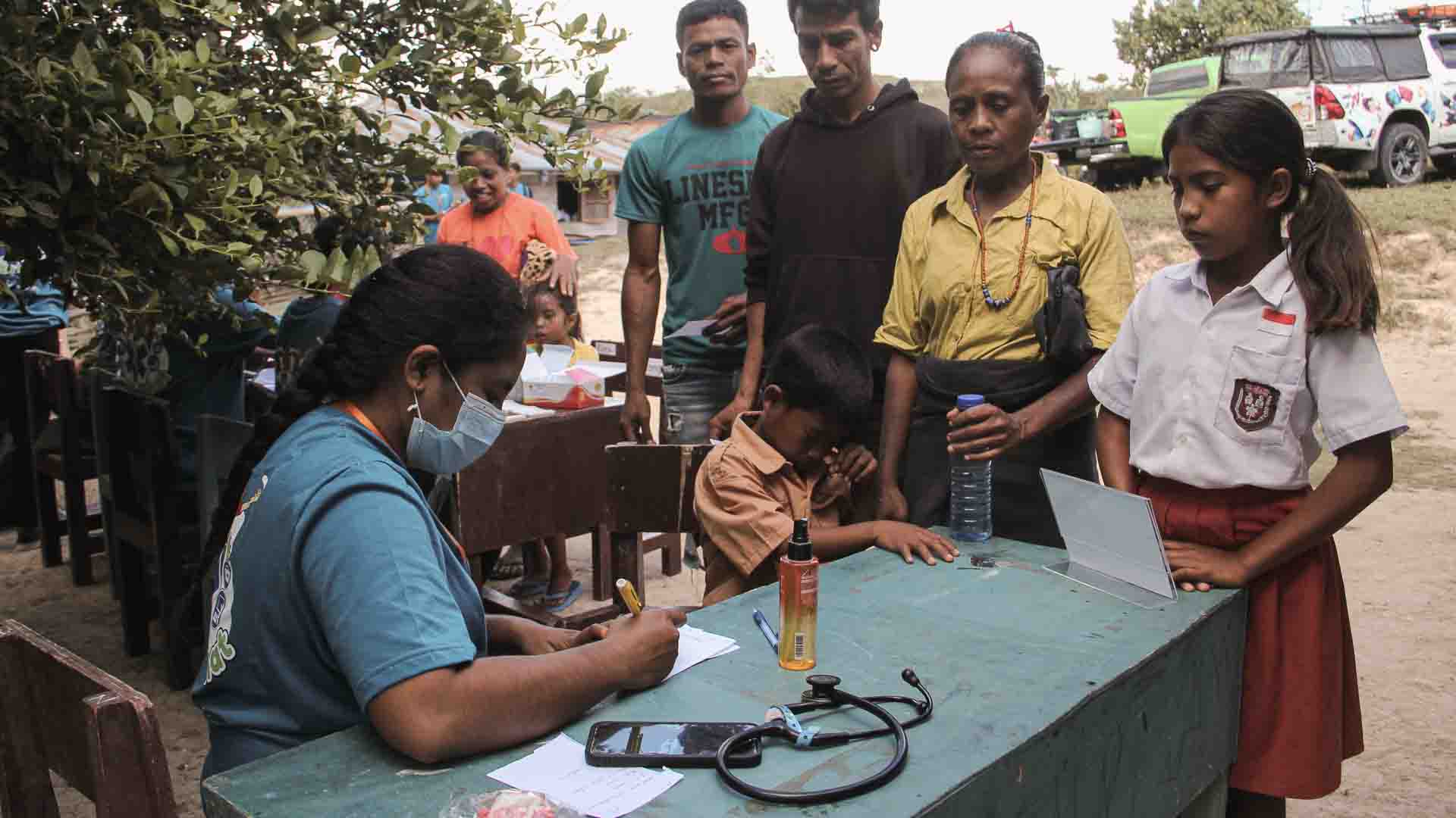 Health agent examining child in rural Indonesia under antibiotics without laboratories protocol