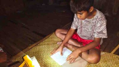 Child receiving a SolarBuddy solar lamp in an ultra-rural school without electricity