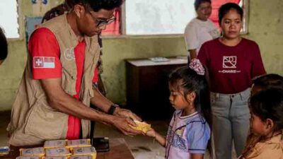 Child receiving a SolarBuddy solar lamp in an ultra-rural school without electricity