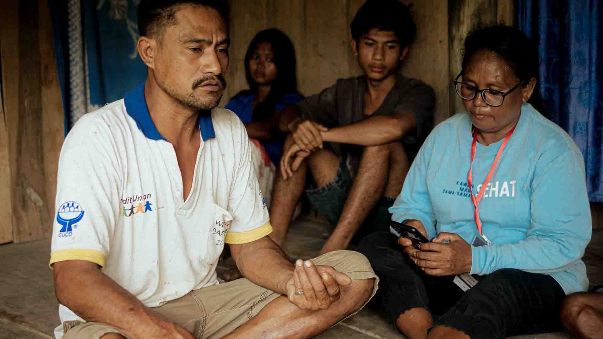 Kawan Sehat agent recording rural health data during home consultation in East Sumba village