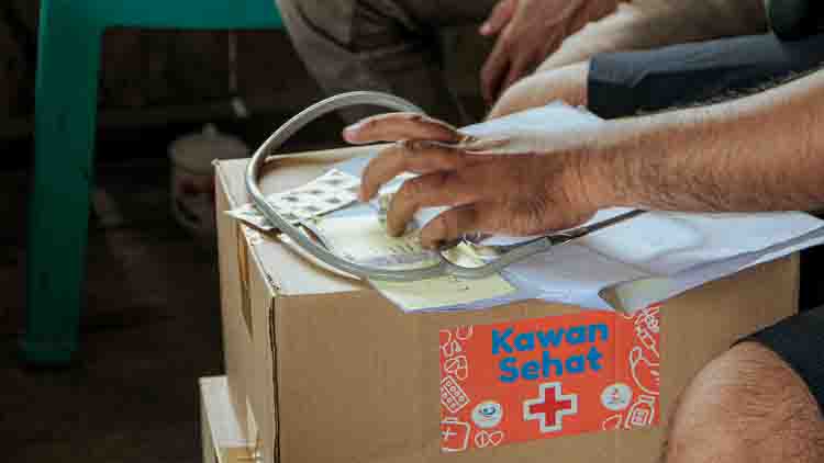 Un agent de santé prépare une trousse médicale Kawan Sehat contenant un stéthoscope et des formulaires médicaux à Sumba Est.