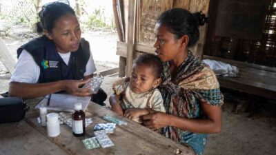 Safe Medicine Guidance in Rural Indonesia • The Fair Future Foundation Health worker explaining safe medicine use to a mother and child in rural Indonesia