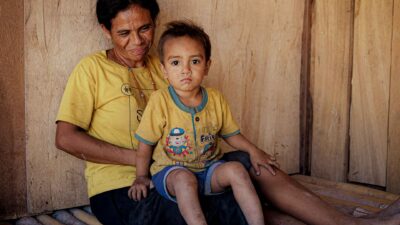 Mother holding her young child at home in rural East Sumba