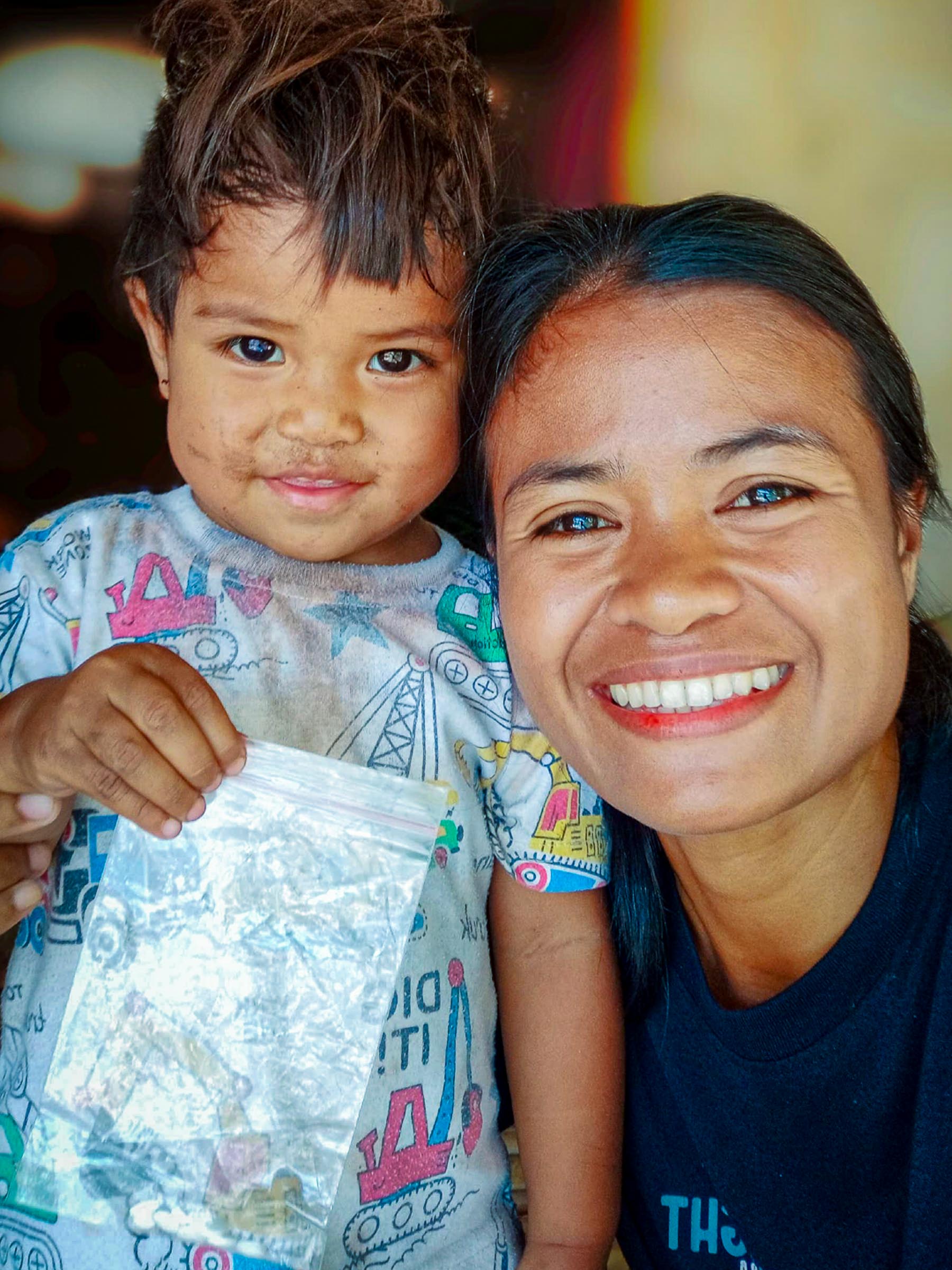 Kawan Sehat health agent with a young child receiving treatment in East Sumba