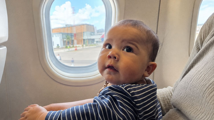 Sorai, huit mois, assis près du hublot d’un avion en Indonésie.