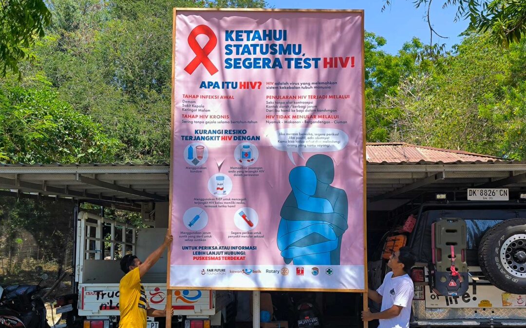 Two Teammates Hold an HIV Testing Billboard Before It Goes Up in Waingapu