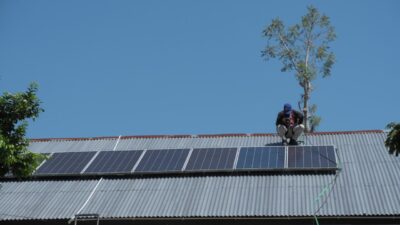 A team member checks rooftop solar panels at SDN Mbajik in East Sumba.
