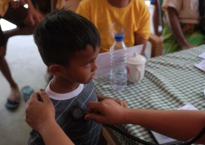 A clinician uses a stethoscope to examine a child’s chest during a consultation.