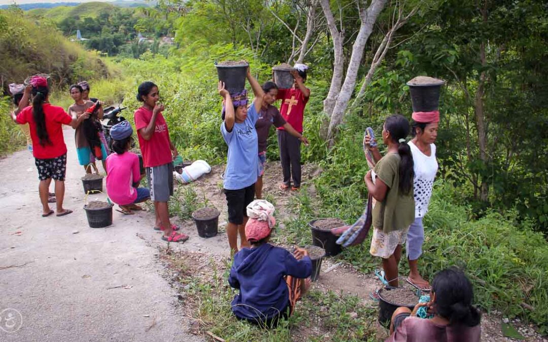 Strong women carry sand for the construction of a new clean water tank