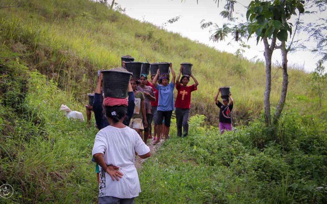 Strong women carry sand for the construction of a new clean water tank