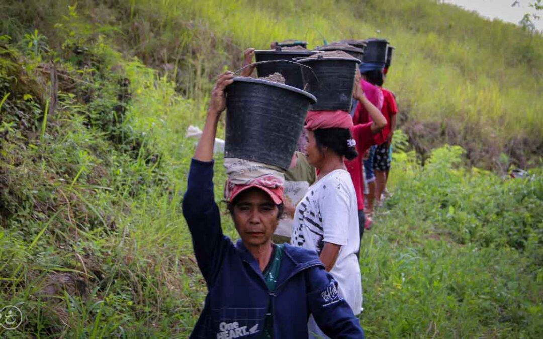 Strong women carry sand for the construction of a new clean water tank