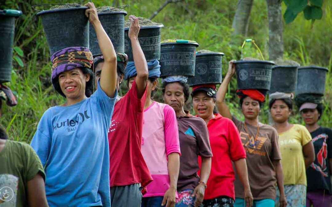 Strong women carry sand for the construction of a new clean water tank