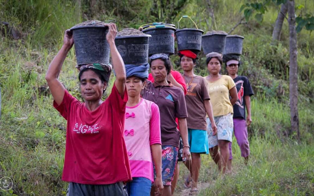 Strong women carry sand for the construction of a new clean water tank