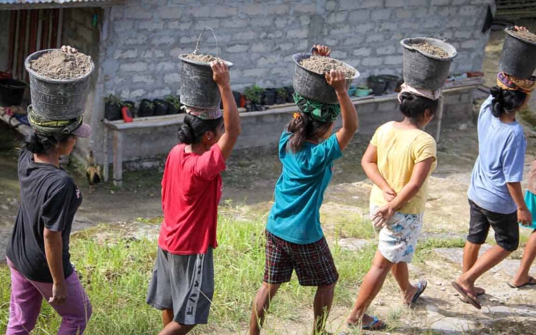 Strong women carry sand for the construction of a new clean water tank