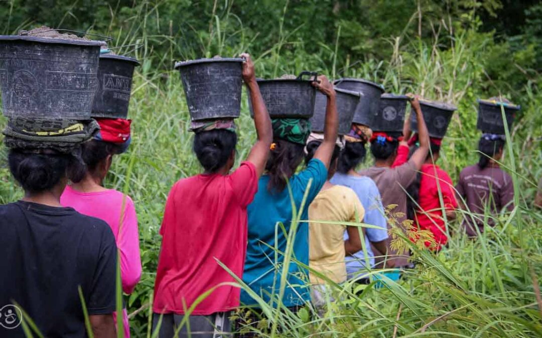 Strong women carry sand for the construction of a new clean water tank