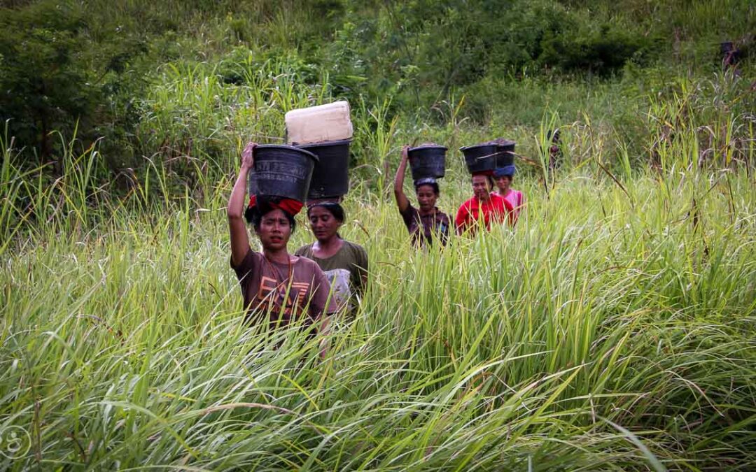 Strong women carry sand for the construction of a new clean water tank