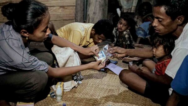 Community Health Broker delivering primary medical care during home visit in East Sumba village.