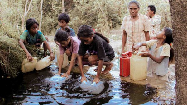 Children collecting unsafe water from a rural stream in East Sumba Indonesia