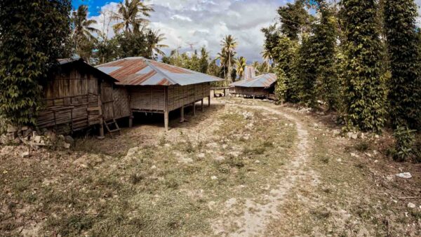 Dirt road leading to isolated village where health systems stop before the village in rural Indonesia