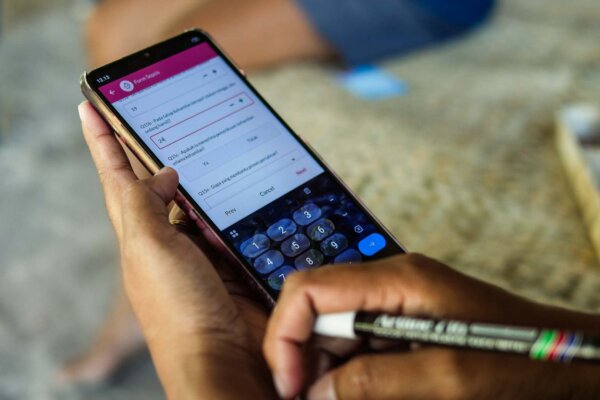 Hands holding a smartphone displaying the Sumba Sepsis Study 2026 survey app during field data collection.